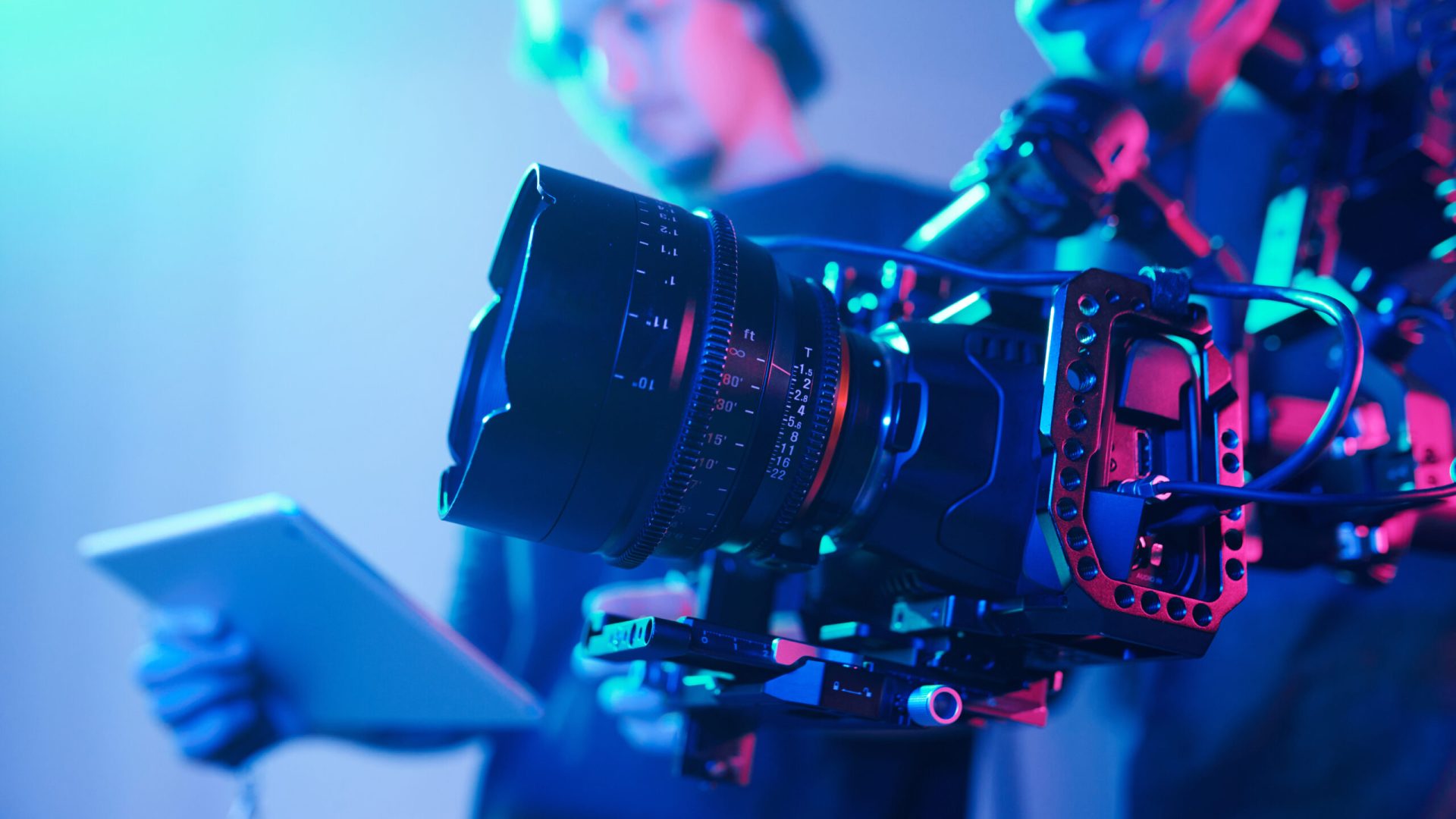 Close-up of operator using professional camera during shooting with director controlling the process